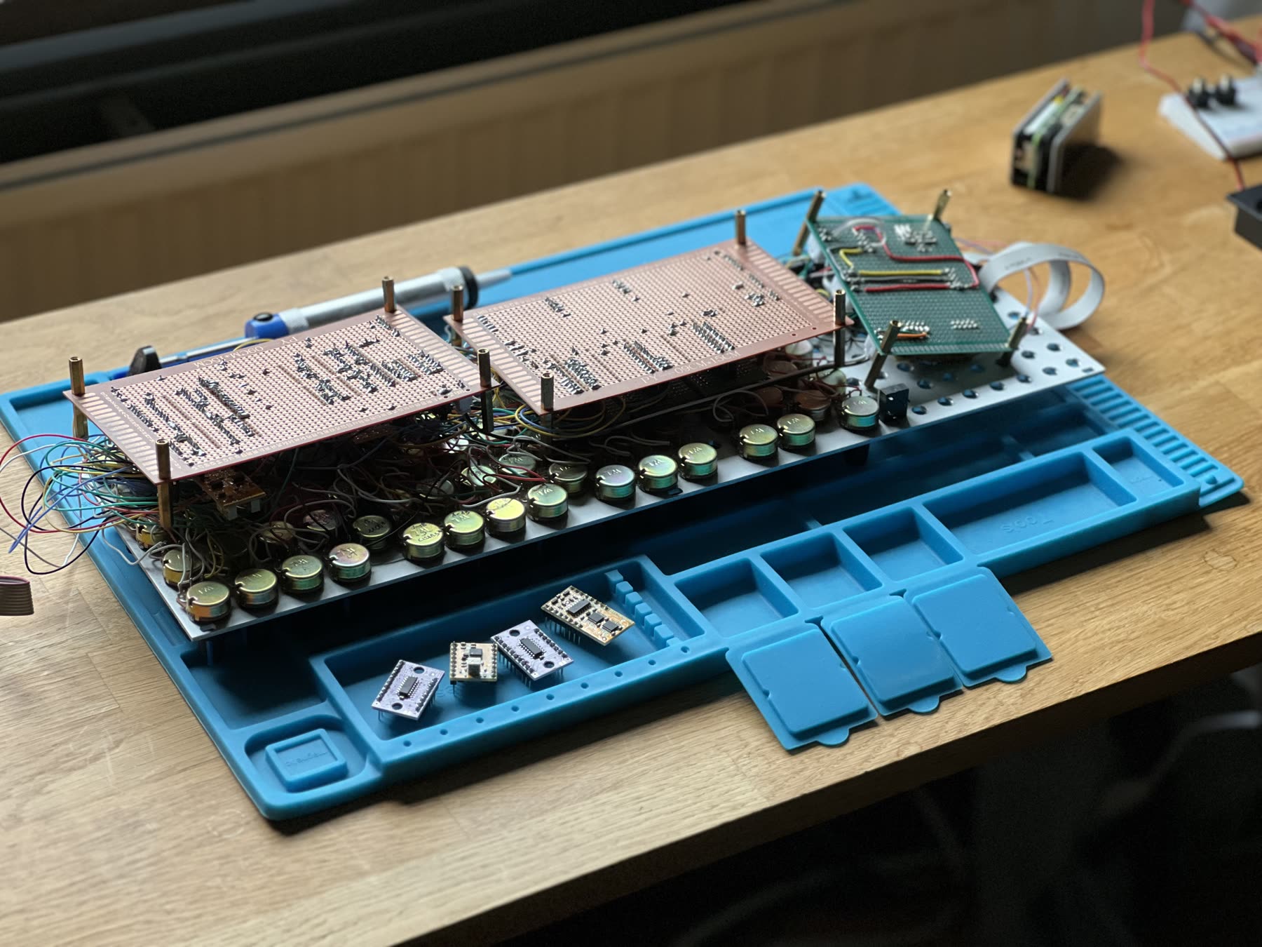 A large hybrid groovebox prototype on a blue electronics work mat.